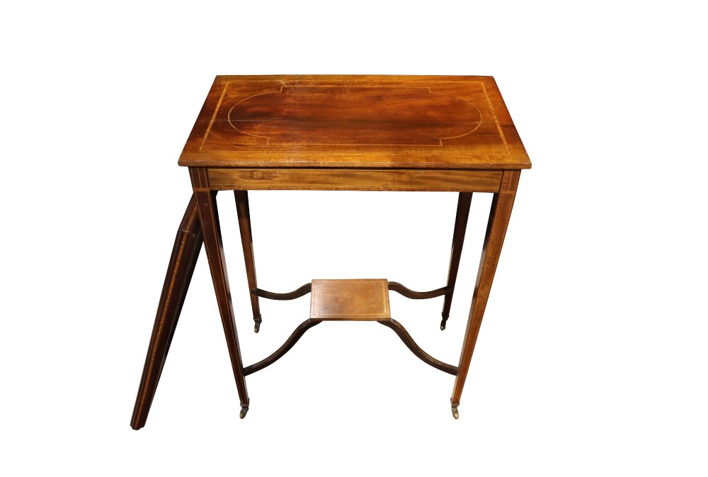An Edwardian mahogany occasional table featuring a removable tray top with brass handles, satinwood string inlay, tapered legs, brass castors, and a lower X-form stretcher with a central platform. View V