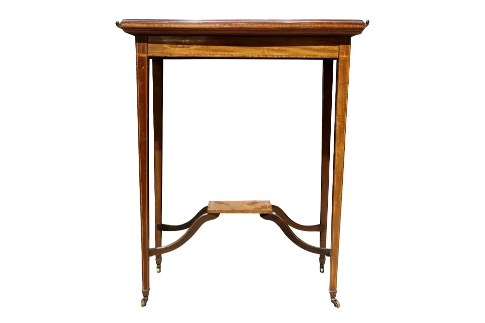 An Edwardian mahogany occasional table featuring a removable tray top with brass handles, satinwood string inlay, tapered legs, brass castors, and a lower X-form stretcher with a central platform. View VI