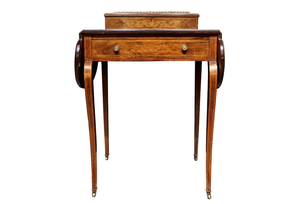 An Edwardian rosewood writing table featuring a green leather writing surface, satinwood floral marquetry inlay, drop-leaf side panels, and a superstructure with brass gallery railing. View III