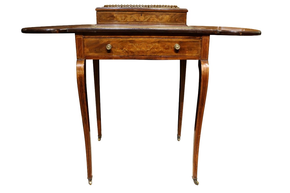 An Edwardian rosewood writing table featuring a green leather writing surface, satinwood floral marquetry inlay, drop-leaf side panels, and a superstructure with brass gallery railing. View VI