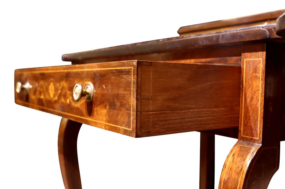 An Edwardian rosewood writing table featuring a green leather writing surface, satinwood floral marquetry inlay, drop-leaf side panels, and a superstructure with brass gallery railing. View IX