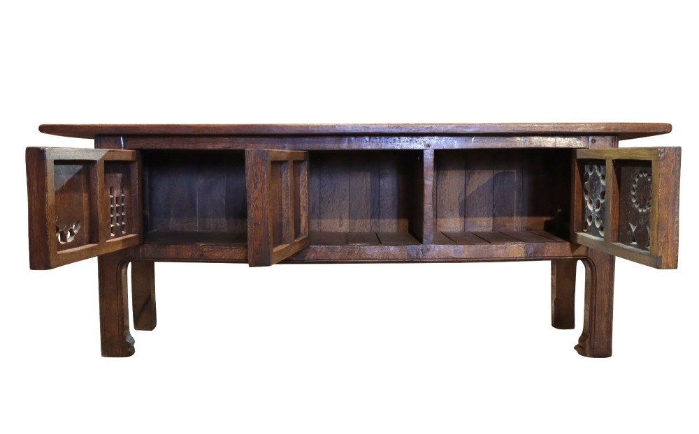 A late 19th-century dark oak Gothic Revival dresser base featuring relief-carved panel doors with geometric tracery and floral motifs. View III