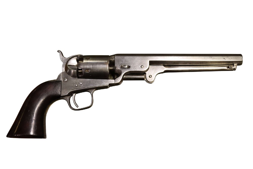 An antique Colt Model 1851 Navy percussion revolver featuring a grey steel frame, an octagonal barrel, a six-shot cylinder, and a dark walnut grip.
