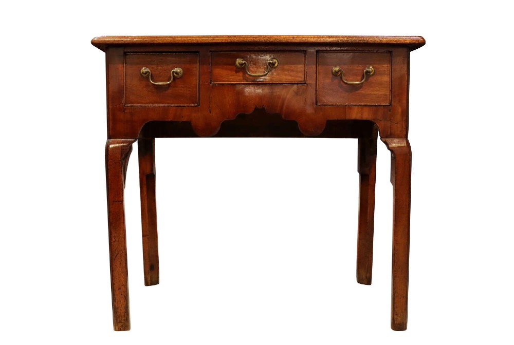 A George II mahogany lowboy table featuring three drawers with brass swan-neck handles and a shaped lower apron.