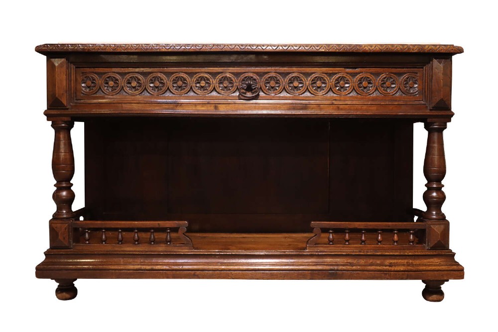 A French Henri II style dark oak enfilade with a carved frieze drawer, turned column supports, and an open lower shelf framed by a spindle rail.