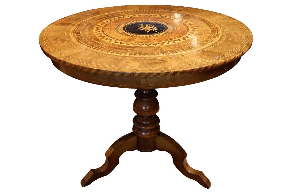 A circular walnut occasional table featuring intricate geometric parquetry and marquetry inlay on a turned central pedestal with three splayed legs.