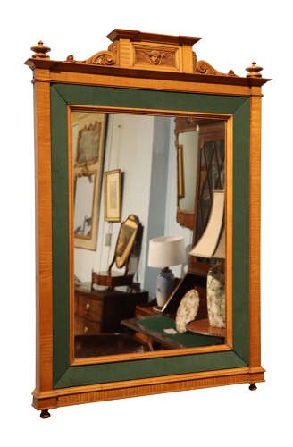 An Edwardian satinwood rectangular wall mirror featuring an inner green fabric border, top pediment with a carved cherub crest, and turned corner finials. View II