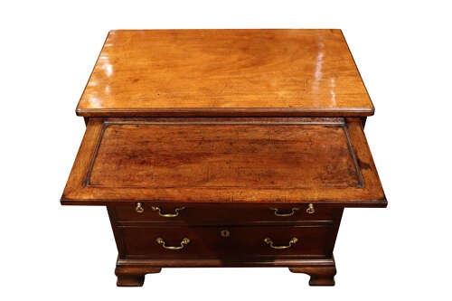 A George III mahogany chest of drawers featuring brass swan-neck handles, an upper brushing slide, and bracket feet. View VI