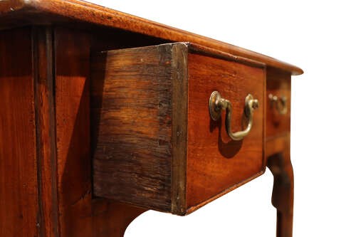 A George II mahogany lowboy table featuring three drawers with brass swan-neck handles and a shaped lower apron. View V
