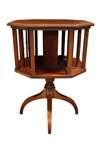 An Edwardian octagonal mahogany revolving bookcase with open spindle sides set upon a turned pedestal stand with tripod legs. View III