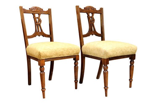 A pair of Victorian carved walnut side chairs with openwork backrests displaying a carved royal crown and monogram, resting on turned front legs with upholstered seats. View III