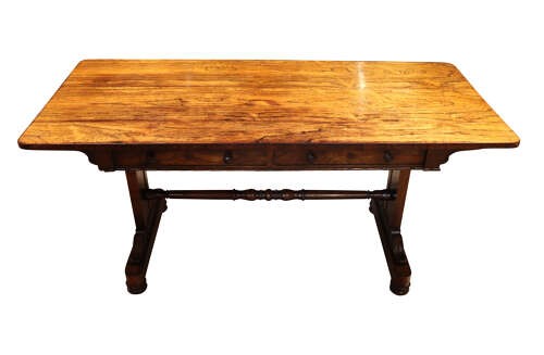 A William IV rosewood library table featuring a rectangular top, two frieze drawers with turned wooden knobs, trestle end supports, and a central turned stretcher. View II