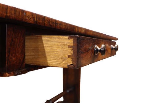 A William IV rosewood library table featuring a rectangular top, two frieze drawers with turned wooden knobs, trestle end supports, and a central turned stretcher. View V