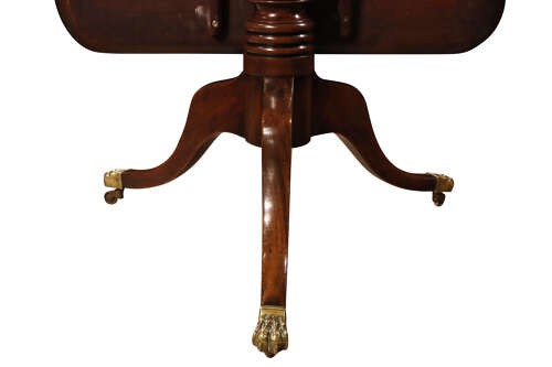 A George III mahogany pedestal supper table featuring a rounded square tilt top, turned central column, and splayed legs with brass paw castors. View V