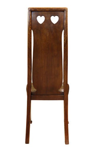 A set of six Arts and Crafts solid oak dining chairs featuring tall backsplats with heart-shaped cutouts and green leather seats with brass studding. View VIII