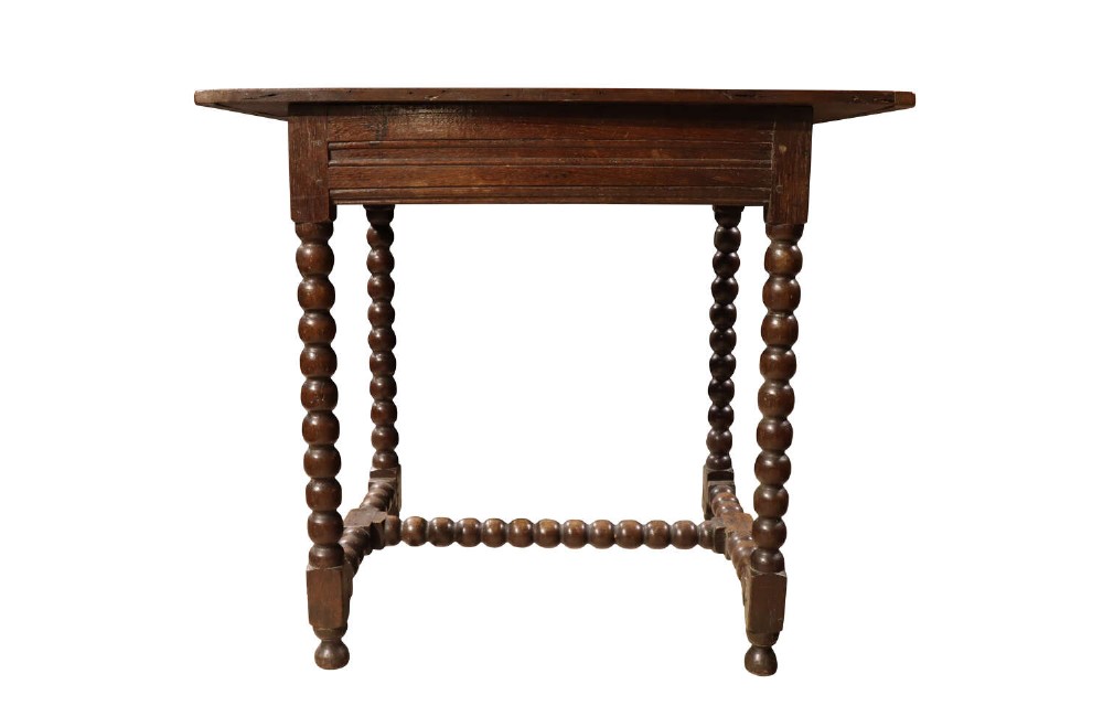 An early 18th-century dark oak side table featuring four bobbin-turned legs connected by matching lower stretchers and a rectangular wooden top.
