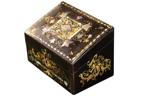 A black lacquered Victorian sloped stationery box adorned with gold leaf scrollwork and mother-of-pearl inlay. View V