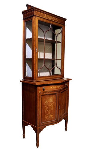 An Edwardian inlaid mahogany display cabinet featuring a glazed top door with geometric tracery above a lower cupboard with floral marquetry. View IV