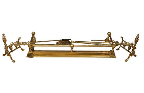 A set of early 20th-century brass fireplace accessories featuring a pair of fire dogs, a shovel with a pierced blade, tongs, poker, and rest. View IV