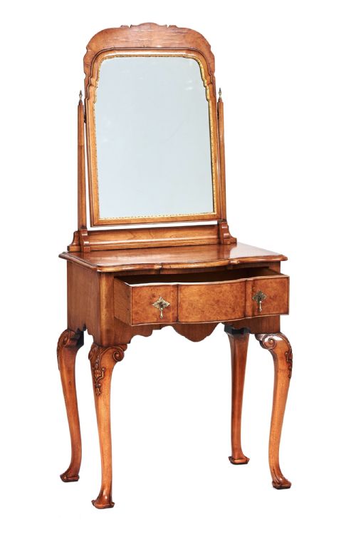 fig 1. A Queen Anne Revival walnut dressing table featuring an attached arched swing mirror, carved cabriole legs, and a drawer with brass hardware.