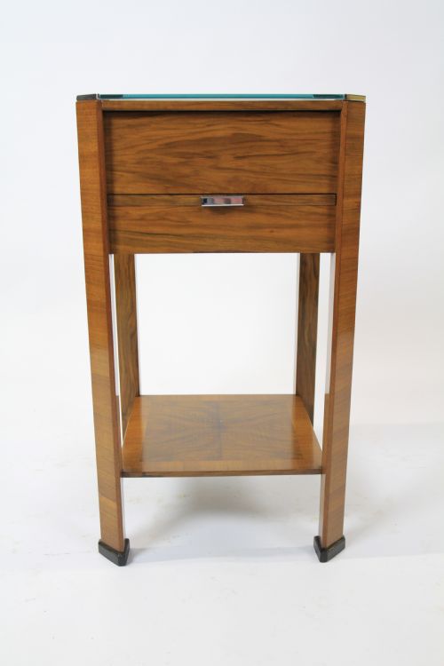 fig 1. An Art Deco two-tier walnut side table featuring a square glass top, chrome corner grips, a lower shelf, and four pull-out maple slides extending from each side.
