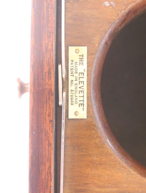 fig 1. An Art Deco walnut elevette drinks cabinet with opened top leaves revealing a rising central metal pillar mechanism.
