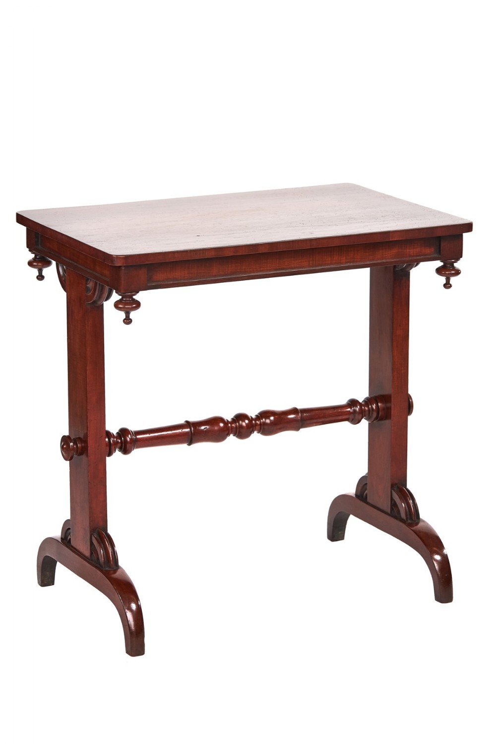 A William IV mahogany end support table featuring corner drop finials, a central turned stretcher, and curved trestle feet.