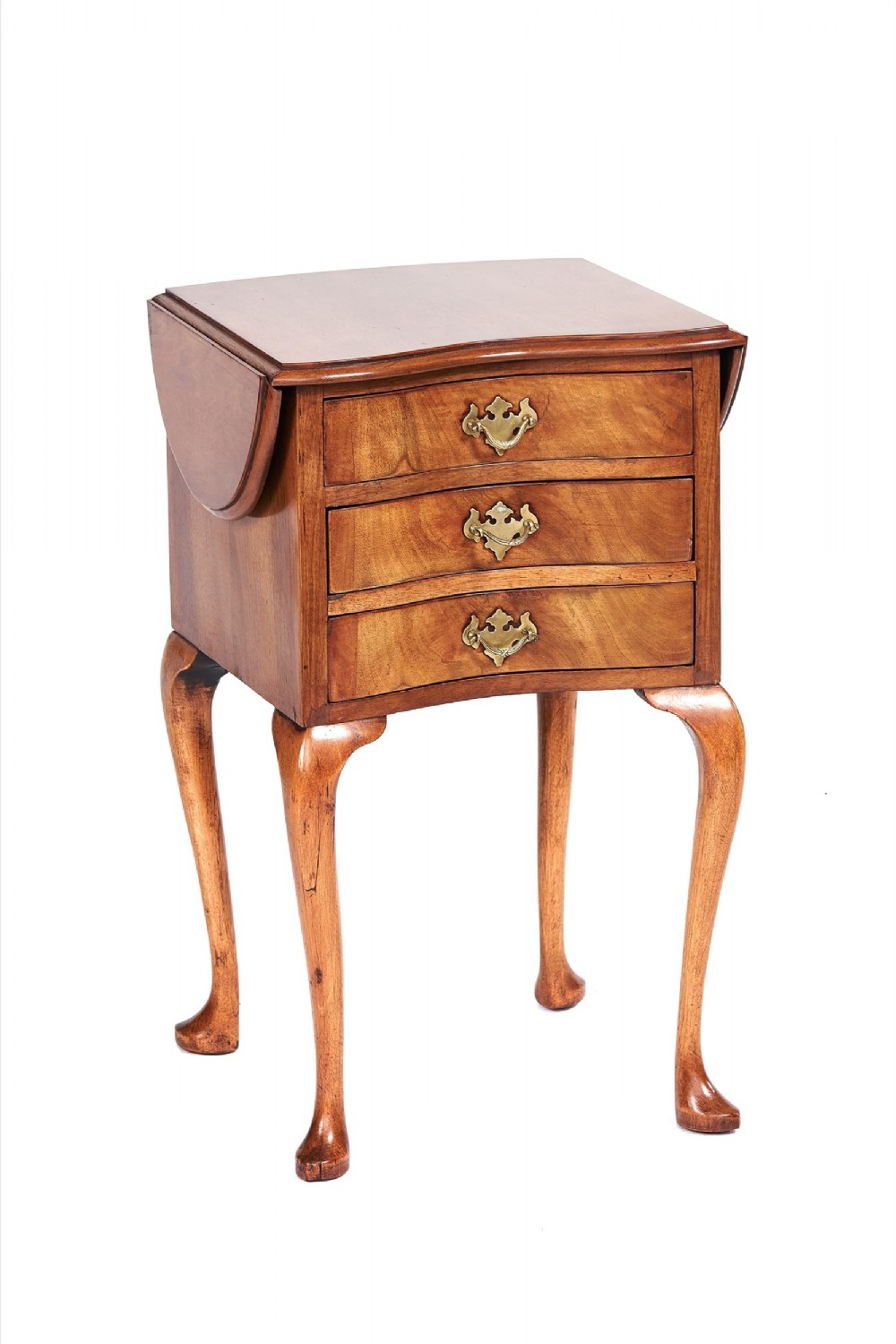 A walnut Georgian style three-drawer drop leaf chest standing on slender cabriole legs with brass handles.