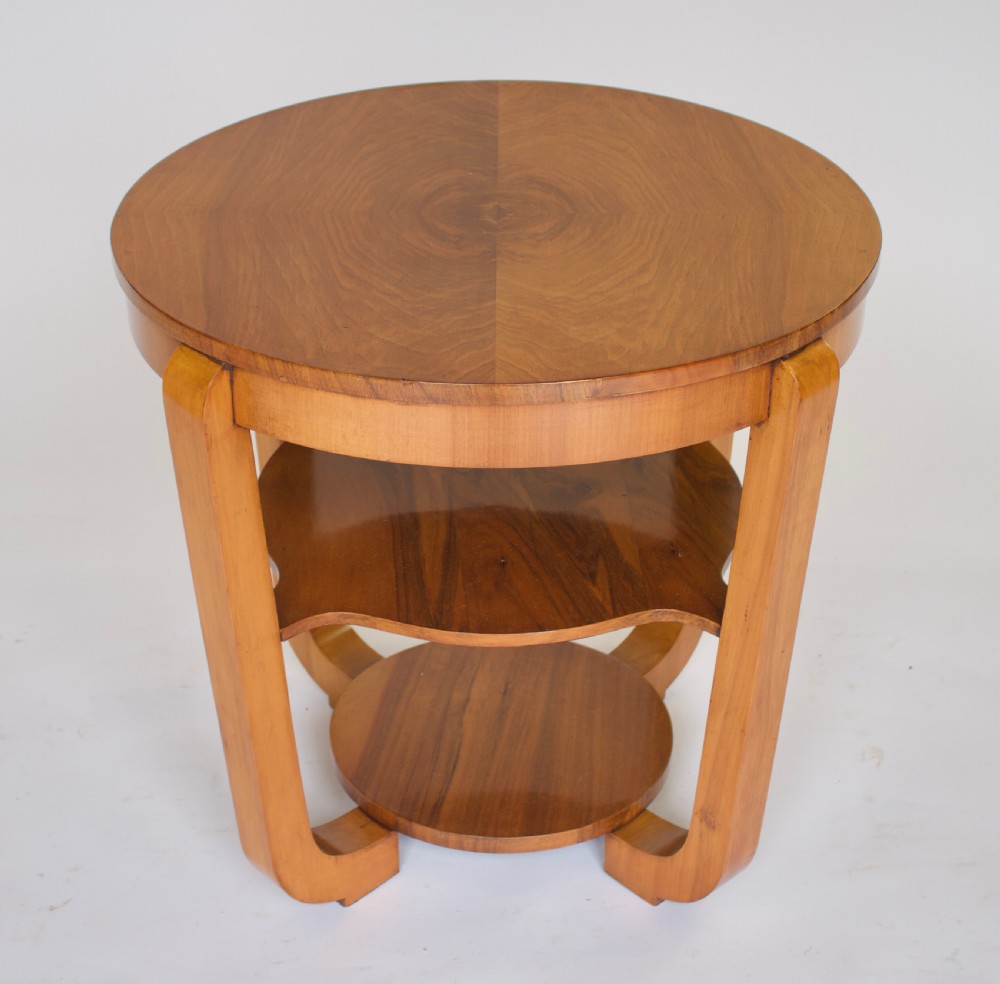 A circular Art Deco walnut side table featuring three tiers and curved leg supports. View IV