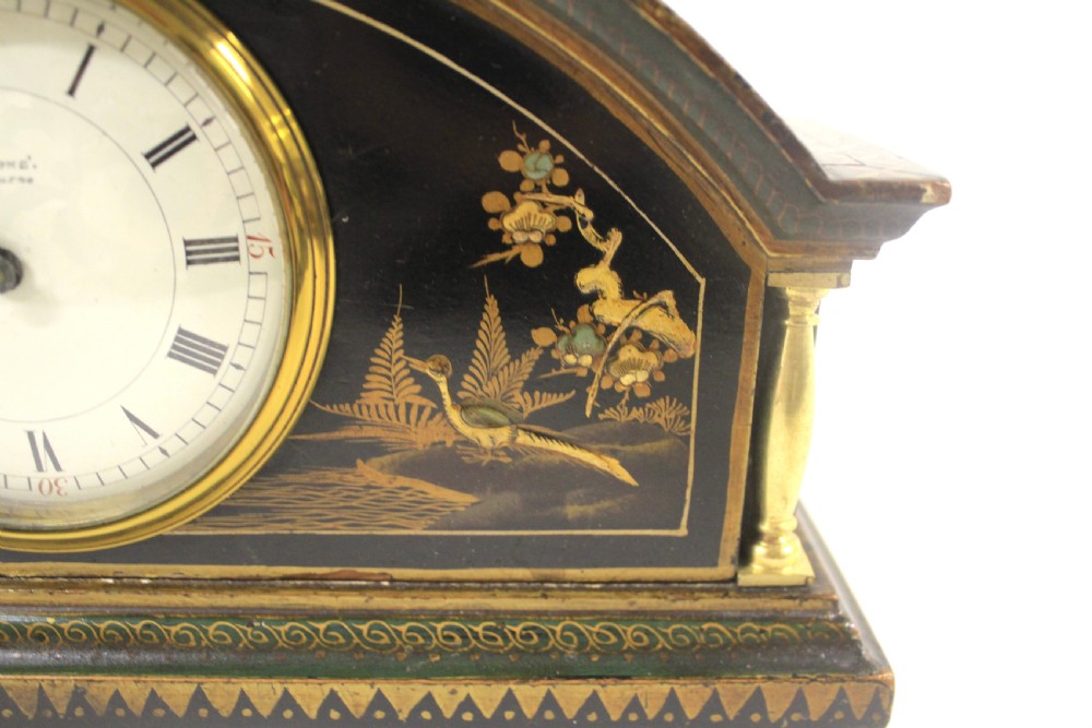 A 1920s arched black lacquered mantel clock decorated with gilded chinoiserie scenes, turned brass columns, and a cream dial with Roman numerals. View III