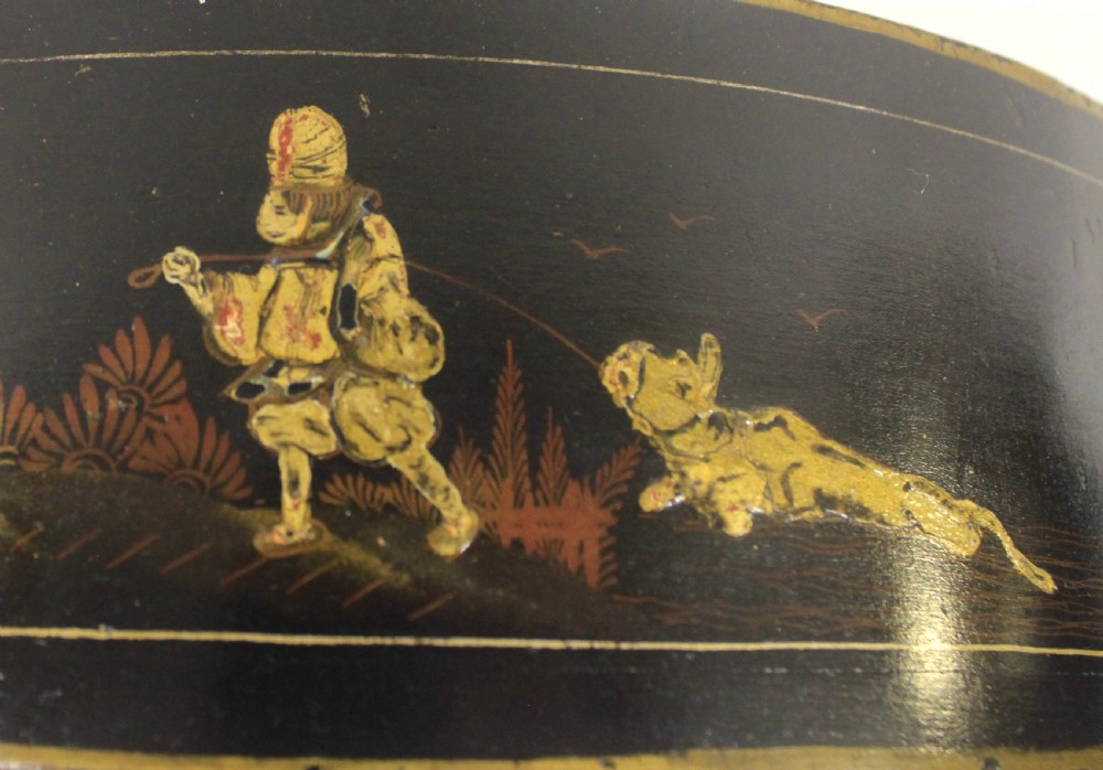 A 1920s arched black lacquered mantel clock decorated with gilded chinoiserie scenes, turned brass columns, and a cream dial with Roman numerals. View IV