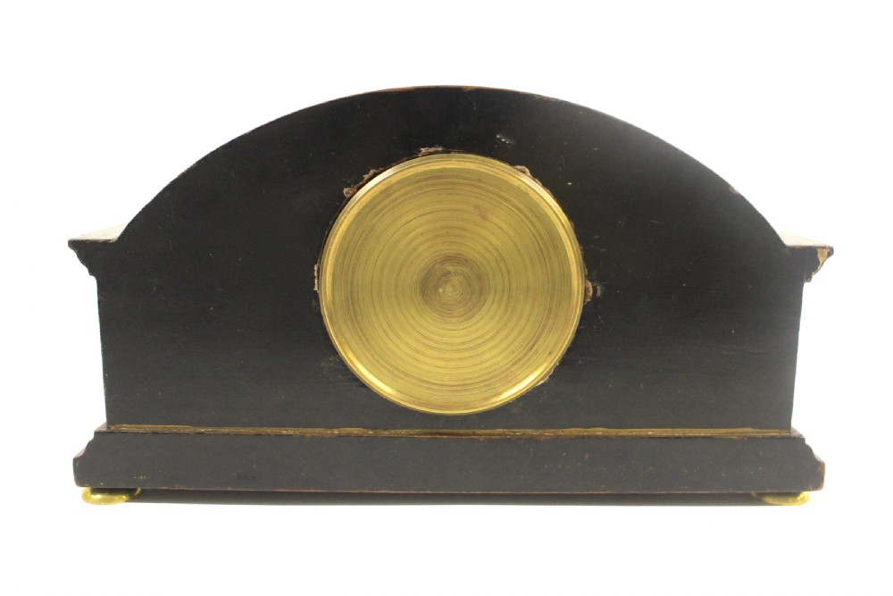 A 1920s arched black lacquered mantel clock decorated with gilded chinoiserie scenes, turned brass columns, and a cream dial with Roman numerals. View VIII