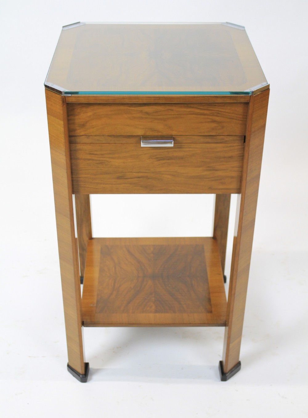 An Art Deco two-tier walnut side table featuring a square glass top, chrome corner grips, a lower shelf, and four pull-out maple slides extending from each side. View IV