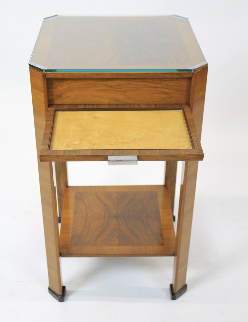 An Art Deco two-tier walnut side table featuring a square glass top, chrome corner grips, a lower shelf, and four pull-out maple slides extending from each side. View V