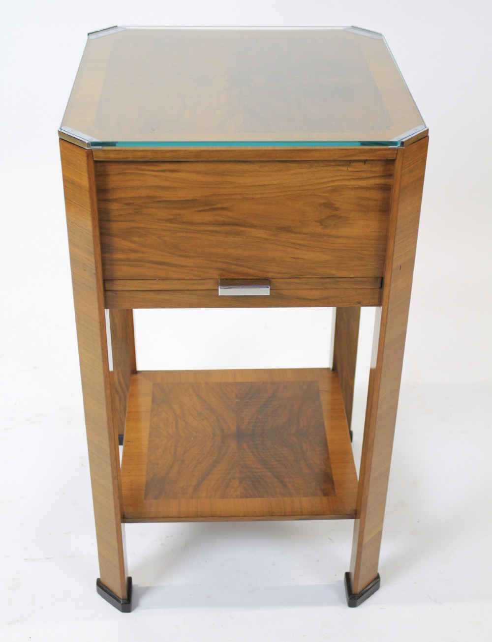 An Art Deco two-tier walnut side table featuring a square glass top, chrome corner grips, a lower shelf, and four pull-out maple slides extending from each side. View VIII