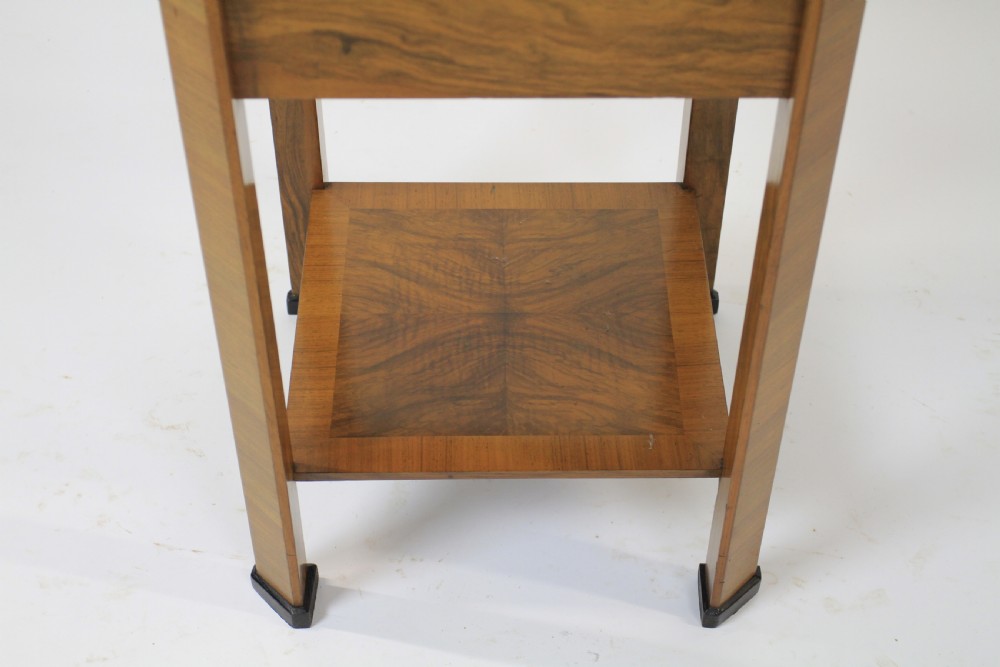 An Art Deco two-tier walnut side table featuring a square glass top, chrome corner grips, a lower shelf, and four pull-out maple slides extending from each side. View XI