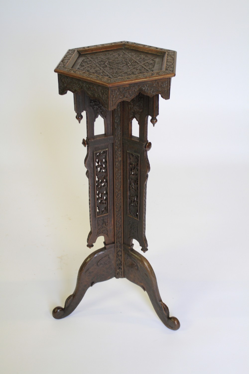 A dark brown carved wood hexagonal lamp table featuring pierced floral panels, a tray top, and curved tripod feet. View II