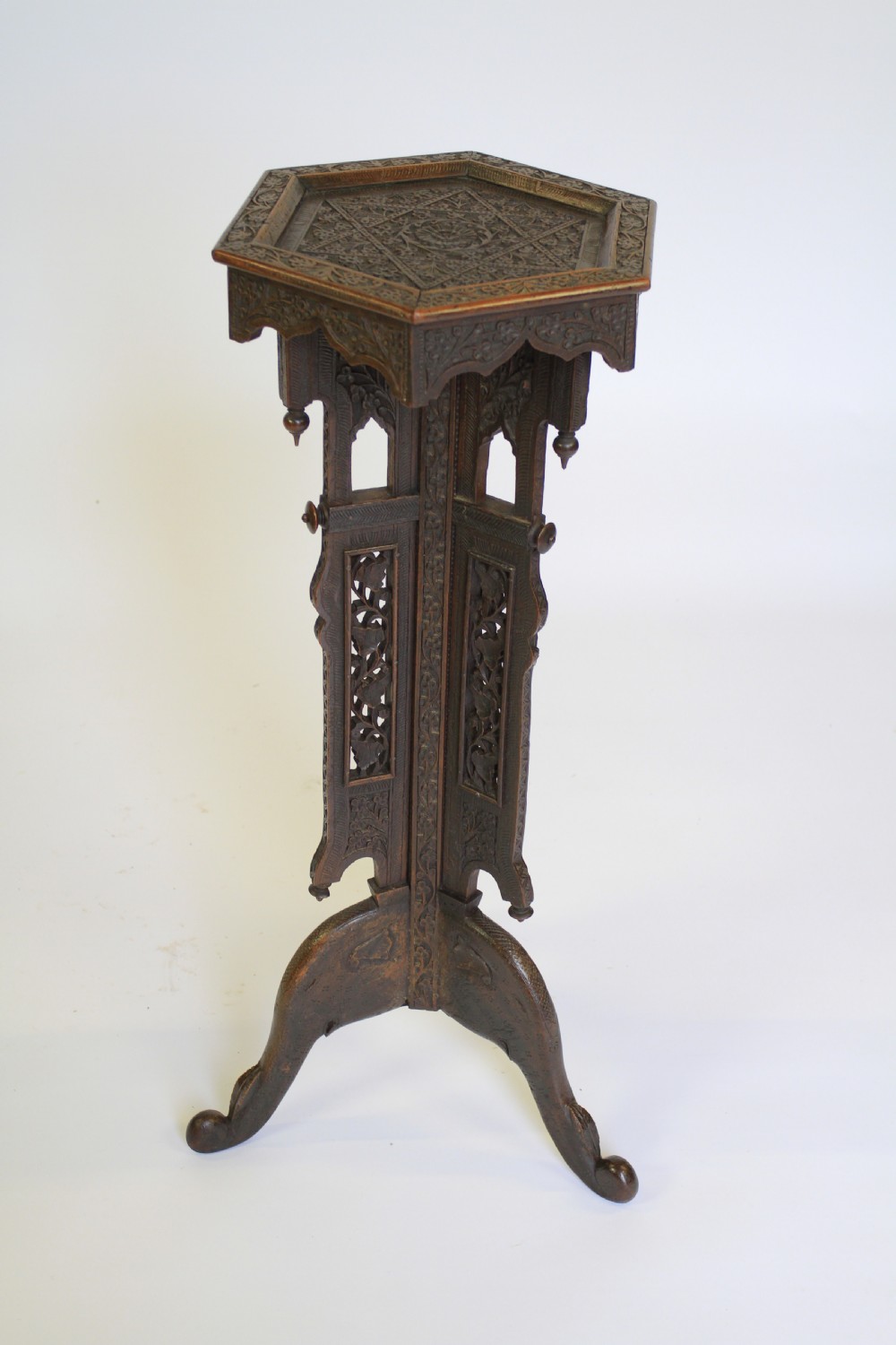 A dark brown carved wood hexagonal lamp table featuring pierced floral panels, a tray top, and curved tripod feet. View III