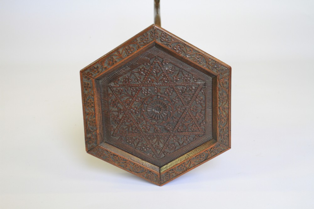A dark brown carved wood hexagonal lamp table featuring pierced floral panels, a tray top, and curved tripod feet. View IV