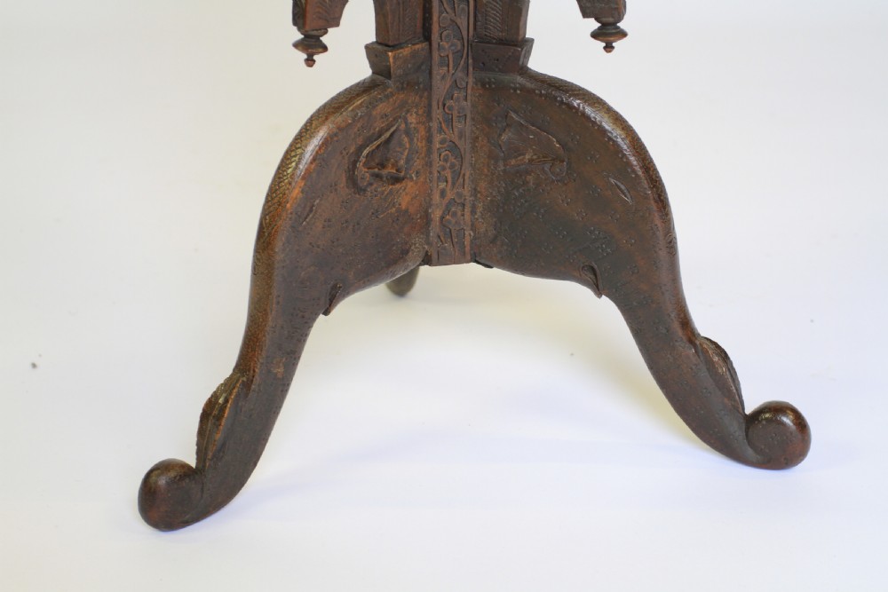 A dark brown carved wood hexagonal lamp table featuring pierced floral panels, a tray top, and curved tripod feet. View V