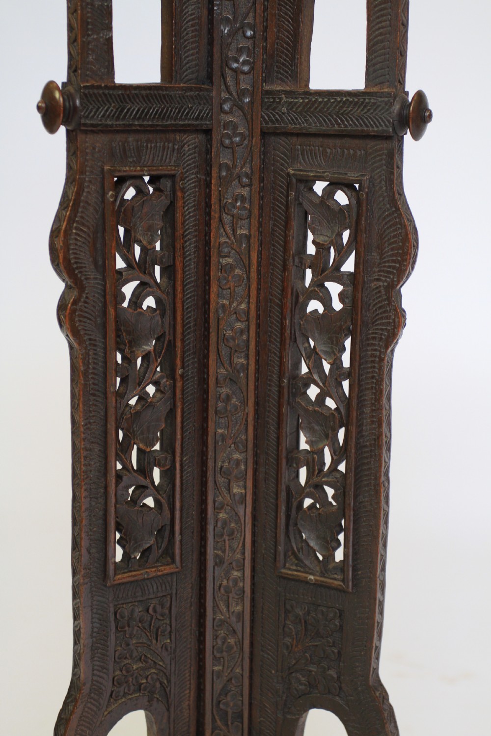 A dark brown carved wood hexagonal lamp table featuring pierced floral panels, a tray top, and curved tripod feet. View VI