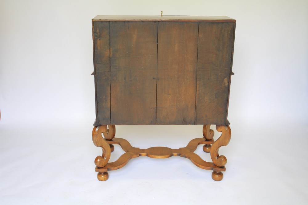 A William and Mary Revival walnut slant-front writing bureau with brass handles and carved scroll legs connected by a shaped stretcher. View V