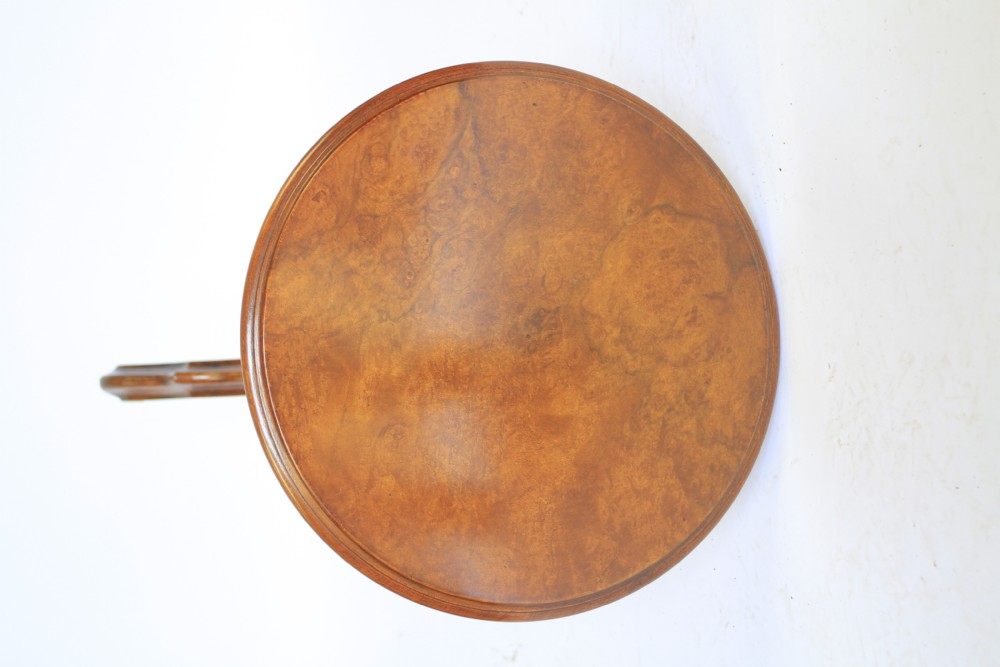 A Victorian circular burr walnut lamp table resting on a carved central column and tripod legs. View III