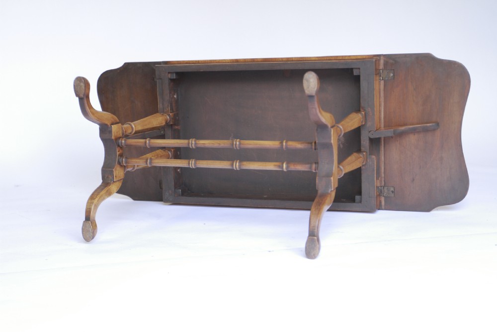 A 1930s walnut drop-leaf coffee table featuring turned supports, pad feet, and a central turned stretcher. View V
