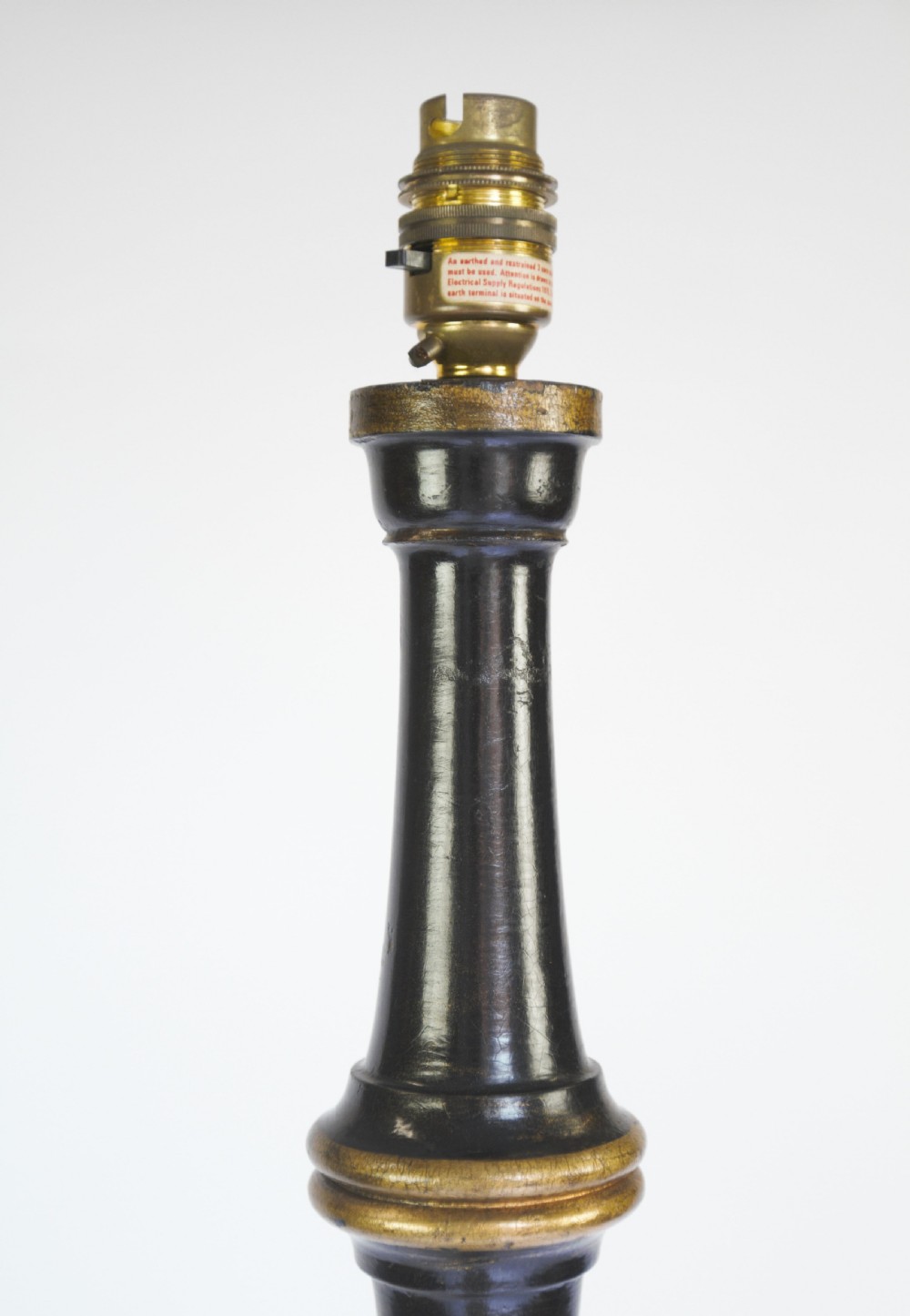 A tall black lacquered turned wooden standard lamp decorated with hand-painted gold floral Chinoiserie designs resting on a circular base. View V