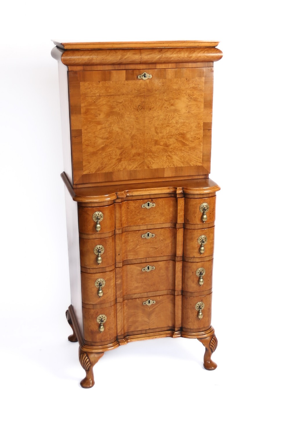 A Queen Anne style burr walnut escritoire featuring a fall-front writing upper cabinet atop a chest of drawers with brass drop handles and carved cabriole legs.