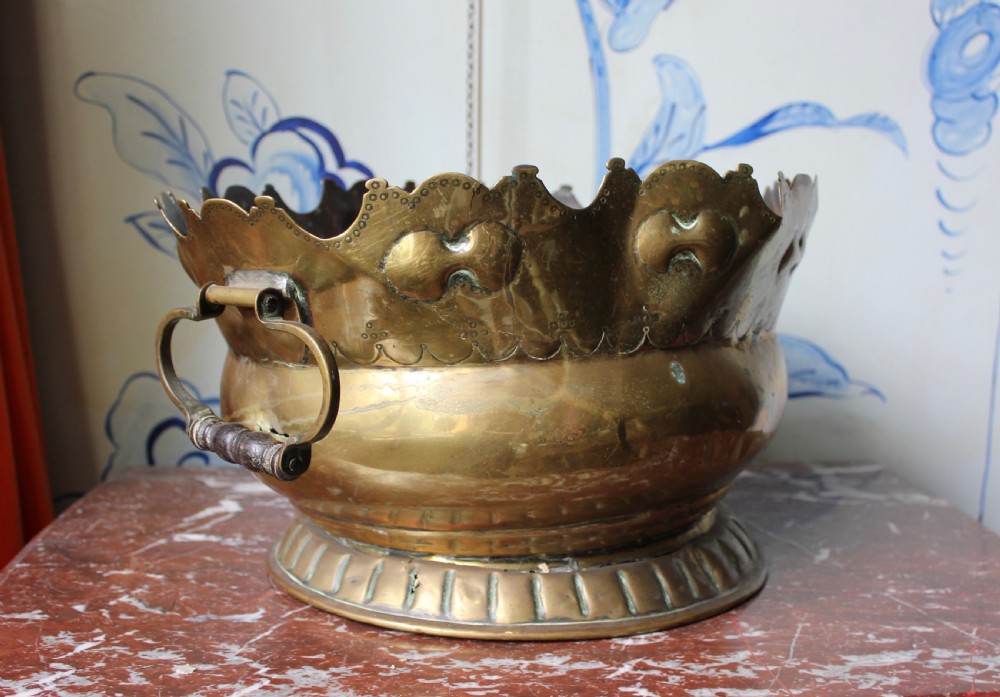 An 18th-century brass monteith bowl featuring a scalloped rim, embossed strapwork motifs, two side loop handles, and a gadrooned foot. View IV