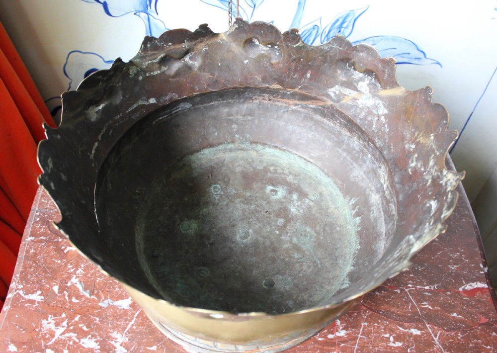 An 18th-century brass monteith bowl featuring a scalloped rim, embossed strapwork motifs, two side loop handles, and a gadrooned foot. View VI