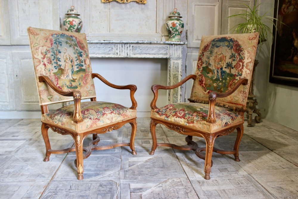 A pair of 19th-century French wooden armchairs with carved floral frames, curved armrests, and high backrests upholstered in woven figural tapestry. View III