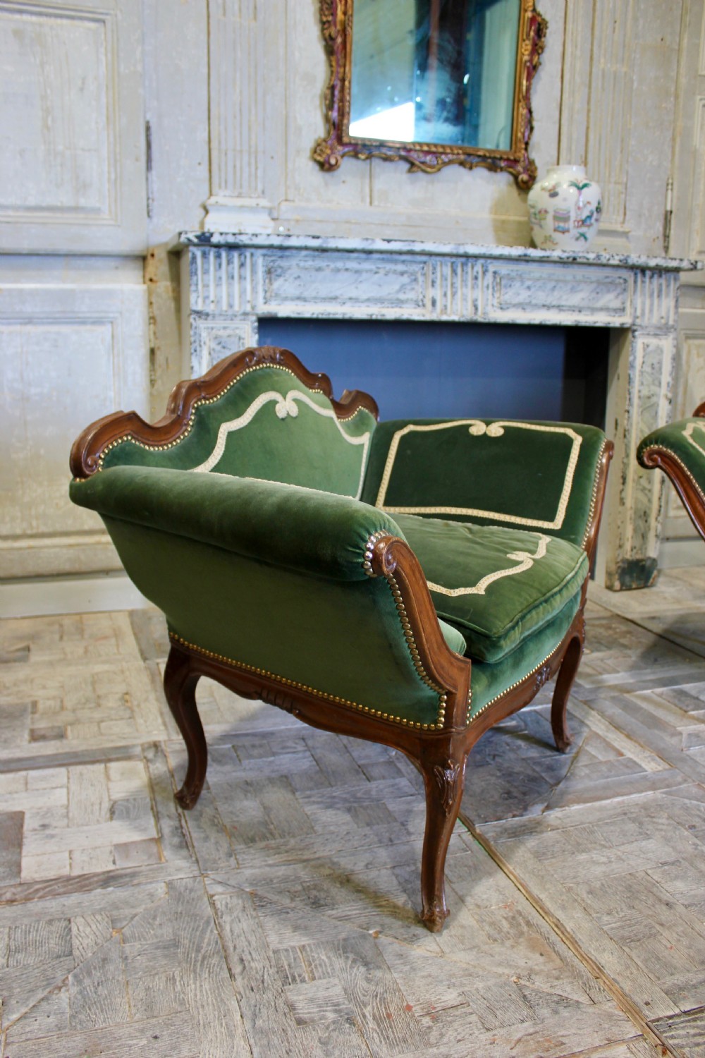 A pair of mid-19th century French Rococo revival armchairs upholstered in forest green velvet with contrasting cream braided trim and carved timber frames. View II